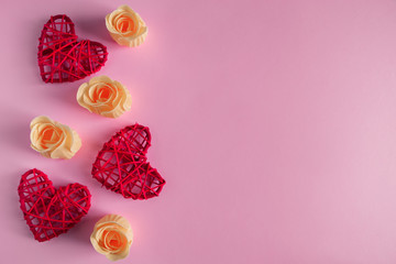 Red hearts and rosebuds on a pink background, concept for Valentine's Day.
