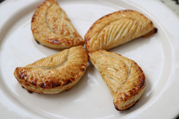 four apple turnovers in pinwheel on white plate