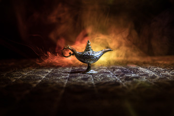 Lamp of wishes concept. Antique Aladdin arabian nights genie style oil lamp with soft light white...