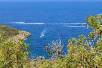 Aerial view of Tirrenic sea with boats, rocks, and vegetation of foreground. Copy space. Monte Argentario, Tuscany, Italy