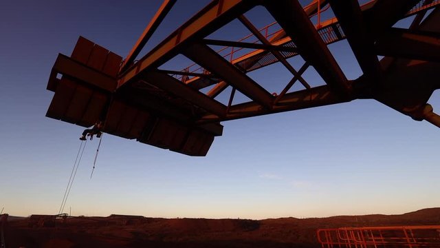 High definition footage of industry rope access technician inspector abseiler abseiling safety descending twins low stretch rope after completed inspecting concrete spalling counterweight at sunset