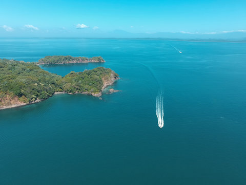 Aerial drone picture of a High speed boat at Chiriqui Panama Pacific Ocean, Parida Island with green trees and blue sea