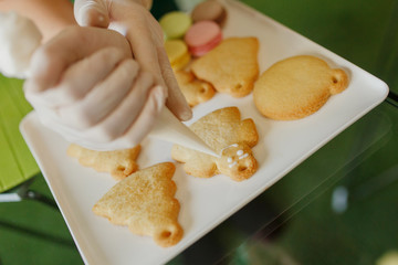 New Year's treats. Confectioner decorates Christmas cookies in the form of men