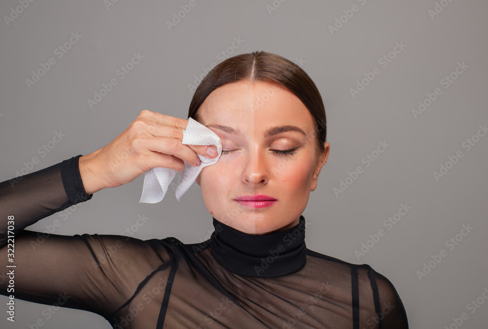 Wall mural beautiful woman removing makeup from her face. beauty concept