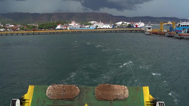 Backward view from the back of a boat facing the port as a ferry leaves East Java, Slow Motion