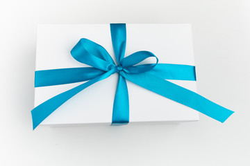 festive white gift box with blue bow