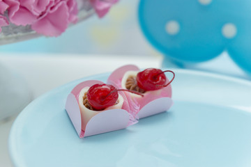 Close up of Tray with chocolate candies topped by a cherry.