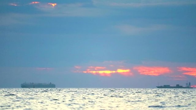 sunset on the sea and focus to chago ship is parking on horizon skyline