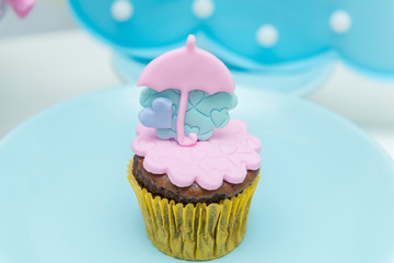 Table of birthday sweets with decorated cupcakes.