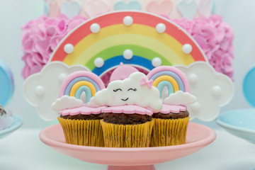 Table of birthday sweets with decorated cupcakes.