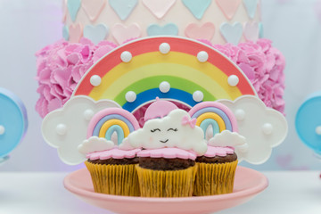 Table of birthday sweets with decorated cupcakes.