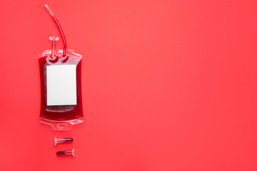Blood pack for transfusion and test tubes on color background