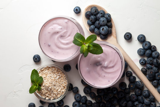 Two Blueberry Yogurt In Glasses On A White Table, Top View, Ingredients For Cooking Diet Food