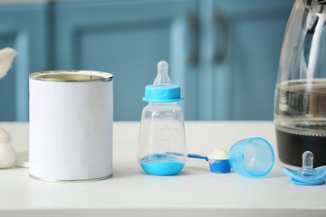 Bottle with baby milk formula on table indoors