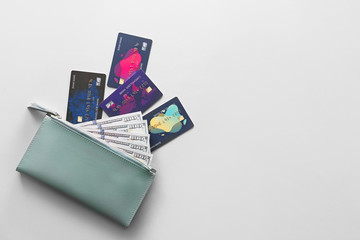 Wallet with credit cards and money on light background