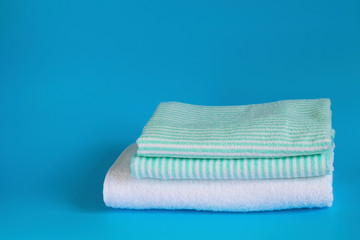 Fototapeta na wymiar Soft terry cotton towel on a blue background. Bath towel. Personal hygiene items..