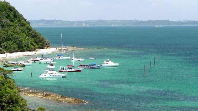 Schooners, yatchs, and other luxury boats parked at paradisiac Ilha dos Frades beach, near Salvador, Bahia, Brazil