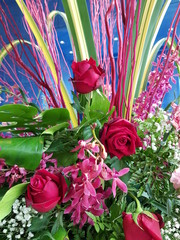 Closeup of beautiful red roses and pink orchids blurred background.