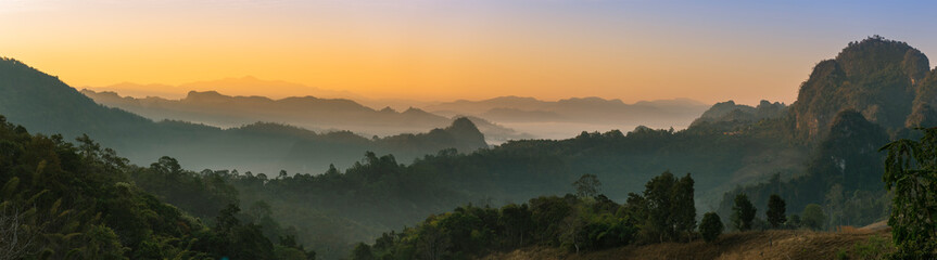 Beautiful sunrise in mountains with white fog below panorama