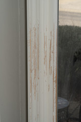 Trim moulding around a door frame is scratched and reveals bare wood underneath the paint