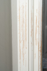 Trim moulding around a door frame is scratched and reveals bare wood underneath the paint