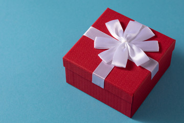 Valentine's Day celebration concept. A nice gift from a loved one. Box with a bow on a gentle blue background. Copy space. Flat lay. Close-up.