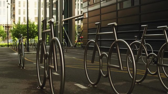 Wide 4K shot with forward slide motion of steel bicycle shaped parking solution in and buildings in the Barcode quarter of the new Bj&oslash;rvika project in daylight, in Oslo Norway.