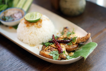 Charcoal-boiled pork neck (grilled pork) served with hot cooked rice, spicy sauce and vegetable, Thai food recipe.