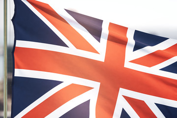 The British flag waving on a daytime sky background . Close Up