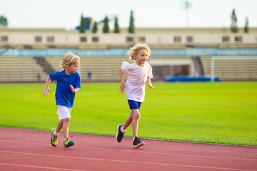 Child running in stadium. Kids run. Healthy sport.