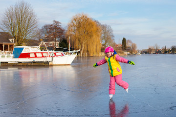 Child ice skating on frozen mill canal in Holland.