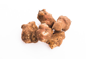 Raw Whole ans sliced Jerusalem artichokes on a white background