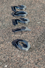 2021 year figures made of metal. Laid out on the stone. Shallow depth of field. There is a tint