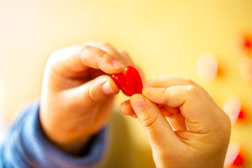 赤いハートのモチーフを持つかわいい子供の指のクローズアップとコピースペース