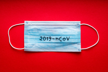 2019-nCoV, Coronavirus - WUHAN virus concept. Surgical mask protective mask on red background....