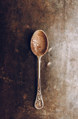 Spoon with dried coffee on the dark rustic background. Selective focus. Shallow depth of field.