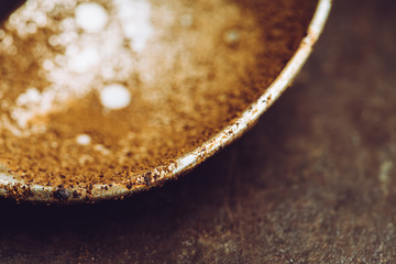 Spoon with dried coffee on the dark rustic background. Selective focus. Shallow depth of field.