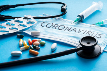 Protective face mask,pills, syringes and Stethoscope on blue background, against Novel coronavirus...