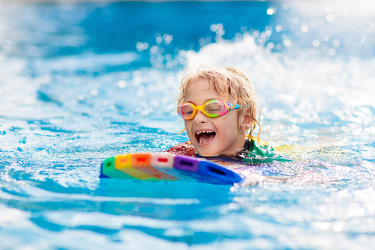 Child learning to swim. Kids in swimming pool.