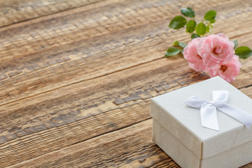 Gift box on wooden boards with rose flowers