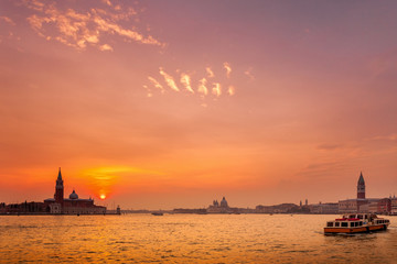 Naklejka premium Wide view of Venice at Sunset with San Giorgio island, Santa Maria Della Salute church and the Campanile in St. Mark's Square seen