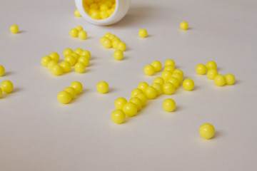 Yellow round tablets or vitamins in a white bubble, on a white background. Concept of medicine. Alternative homeopathy. Flatley. The view from the top. copyright for text.