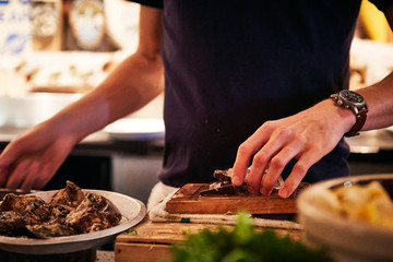 A Restaurant Worker working on shucking Oysters in the kitchen in Vancouver BC Canada