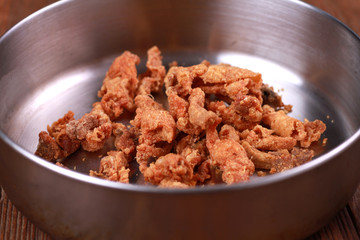 Fried chicken skin on wood table.
