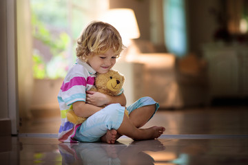 Child playing with teddy bear. Kid and toy at home