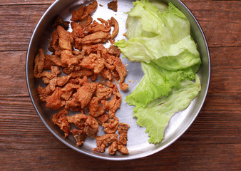 Fried chicken skin on wood table.