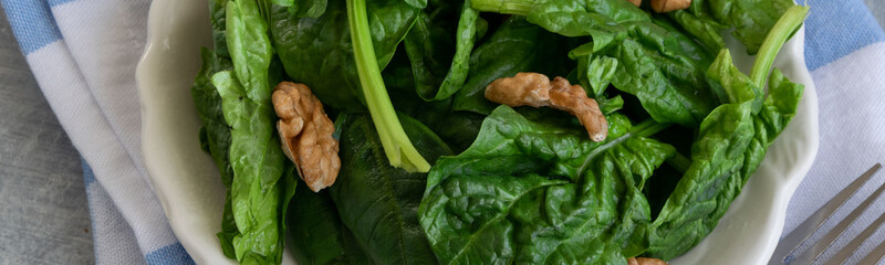 Close up view of raw spinach salad with walnuts