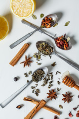 Different herbal tea with honey, lemon and spices on white background.