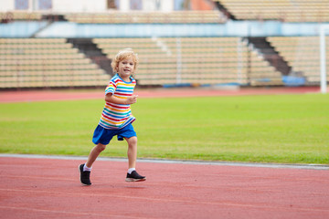 Fototapeta premium Child running in stadium. Kids run. Healthy sport.