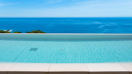 Swimming pool overlooking view andaman sea and clear sky background,summer holiday background concept.